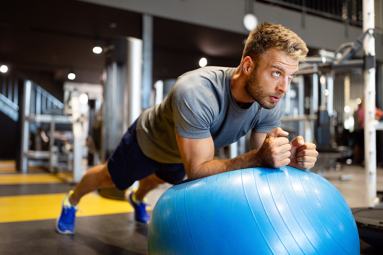 Hombre en gimnasio con pelota de Pilates